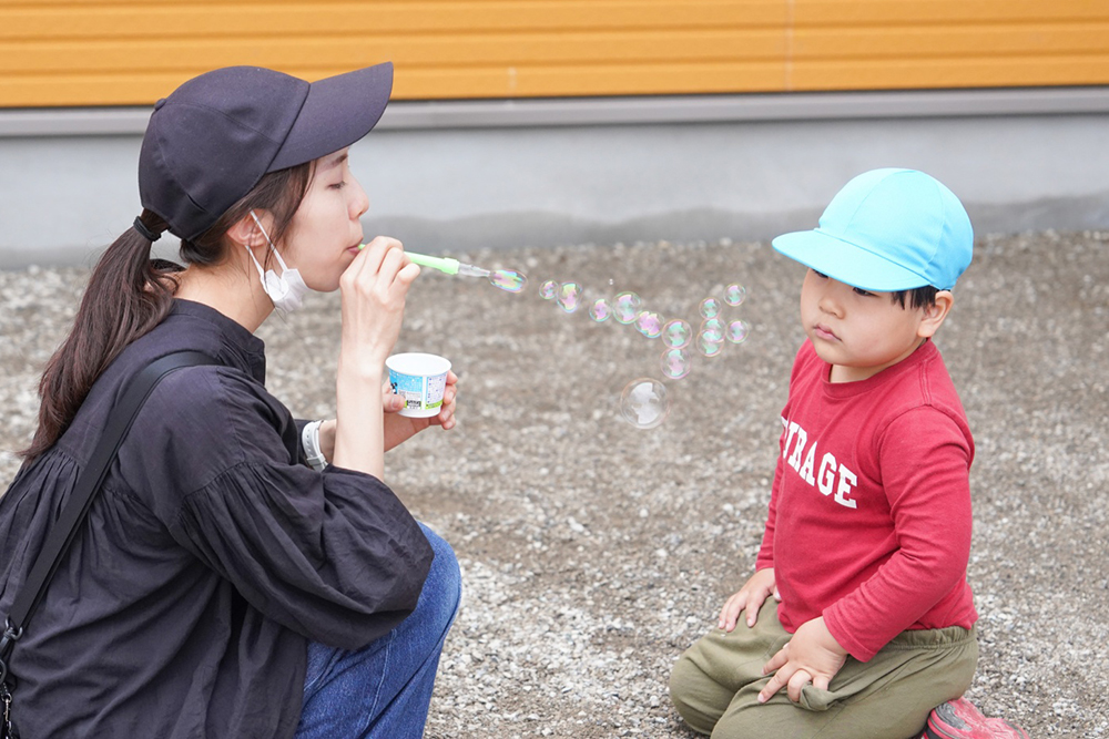 支援員とシャボン玉で遊ぶ男の子